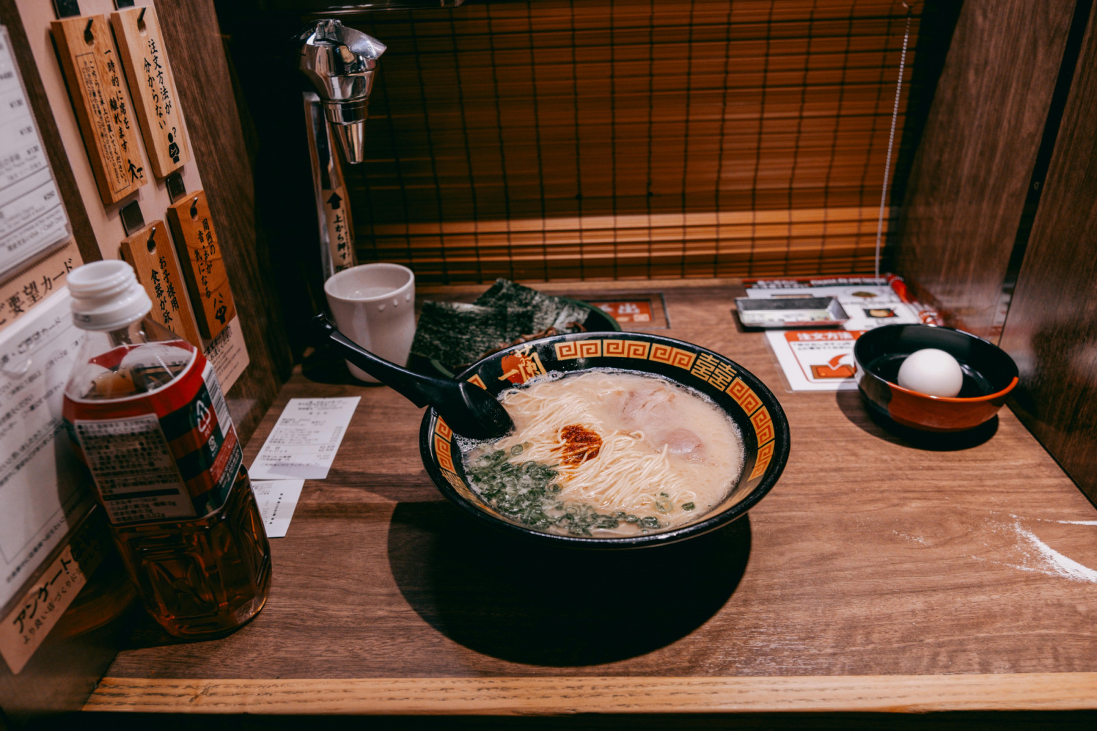 At ramen shops in Tokyo, partitioned booths transform solo dining into a meditative ritual.