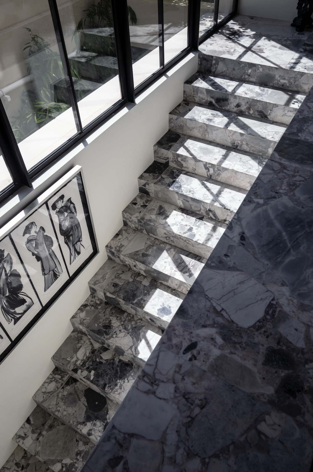 Breccia Grey marble envelops the floors, including this staircase