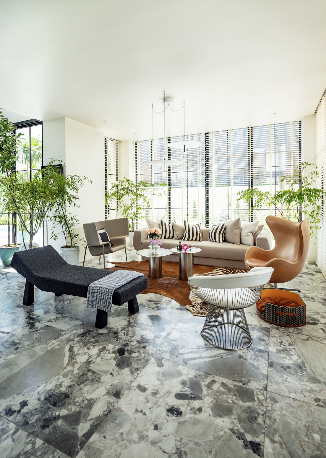 The living room with a custom sofa flanked by Midcentury-era chairs