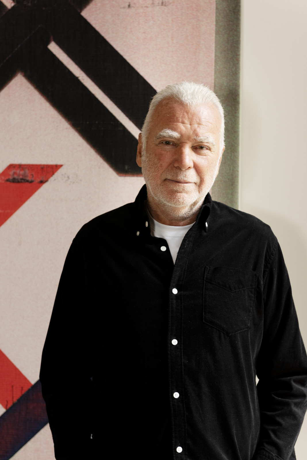 Vintage furniture pioneer Patrick Seguin in his Paris apartment in front of Wade Guyton, Untitled, 2023