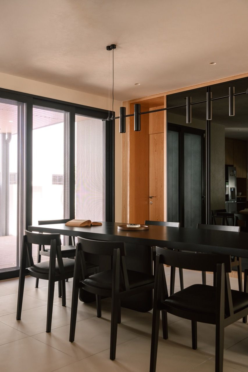 The dining area in this home, renovated by Figs Format, features a custom table base from Dads Wood with a black sintered stone top (Photo: TWJPTO)