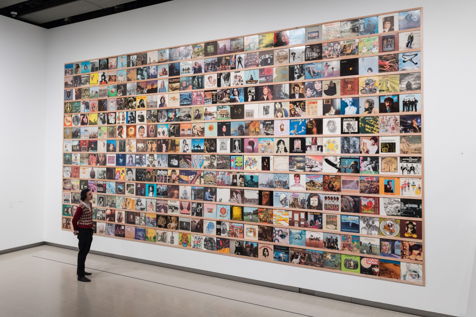 LONDON, UNITED KINGDOM - JUNE 09, 2025: A staff member looks at a selection of record sleeves from Yoshitomo Nara's personal collection that he finds particularly inspiring during a photocall at the Hayward Gallery ahead of the major retrospective exhibition (10 June - 31 August) by the leading Japanese artist in London, United Kingdom on June 09, 2025. (Photo credit should read Wiktor Szymanowicz/Future Publishing via Getty Images)