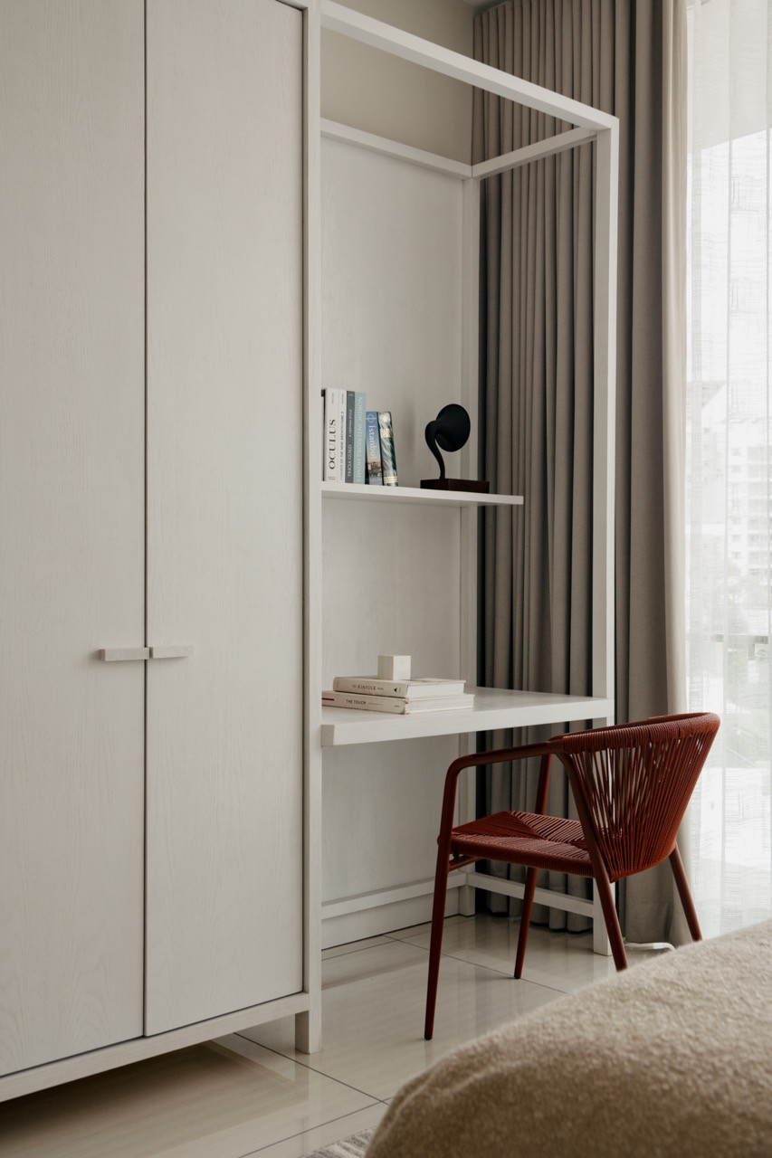 A minimalist study corner features clean-lined furniture and integrated storage that supports both work and display functions