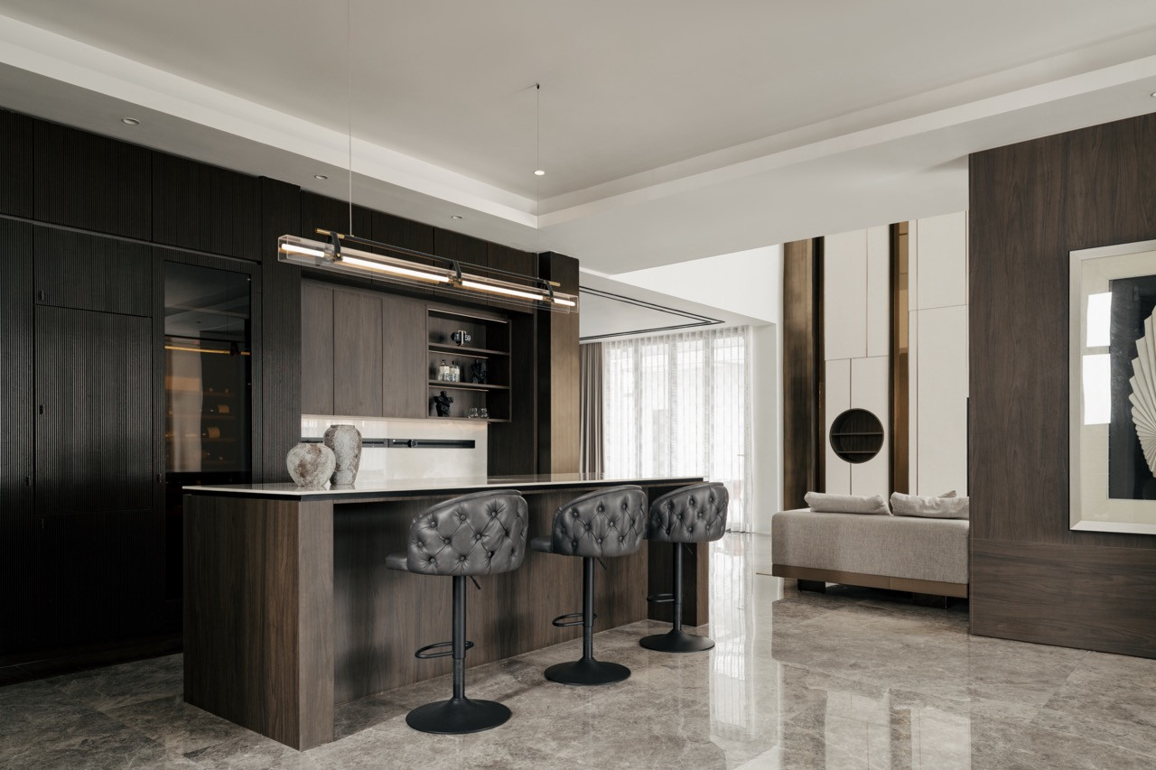 A wider view of the kitchen shows how the black fluted cabinetry creates visual drama