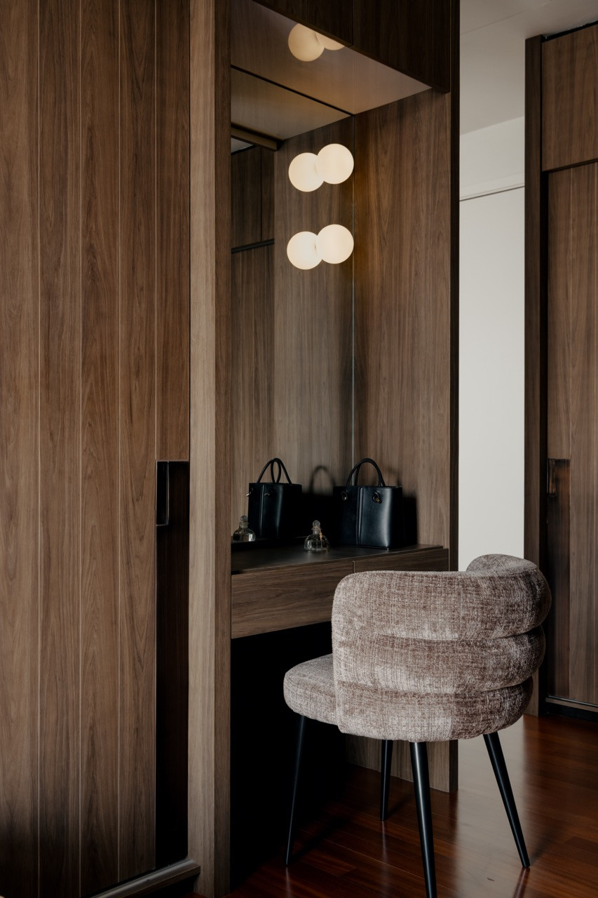 A dressing area reveals the attention to detail in custom millwork, with illuminated displays and carefully planned storage for personal accessories