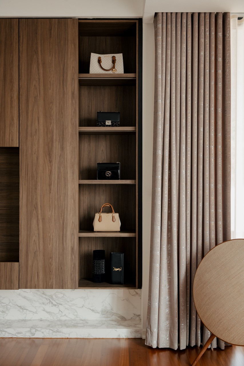 Open shelving in the bedroom displays curated accessories while maintaining the project’s material consistency