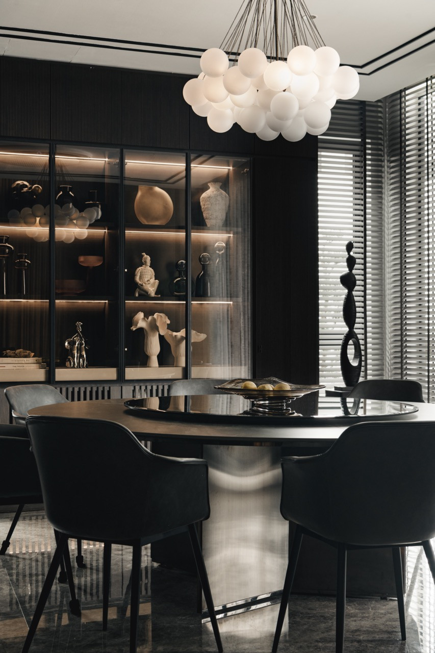 The formal dining room is fitted with illuminated display cabinets showcasing family collections and a statement chandelier