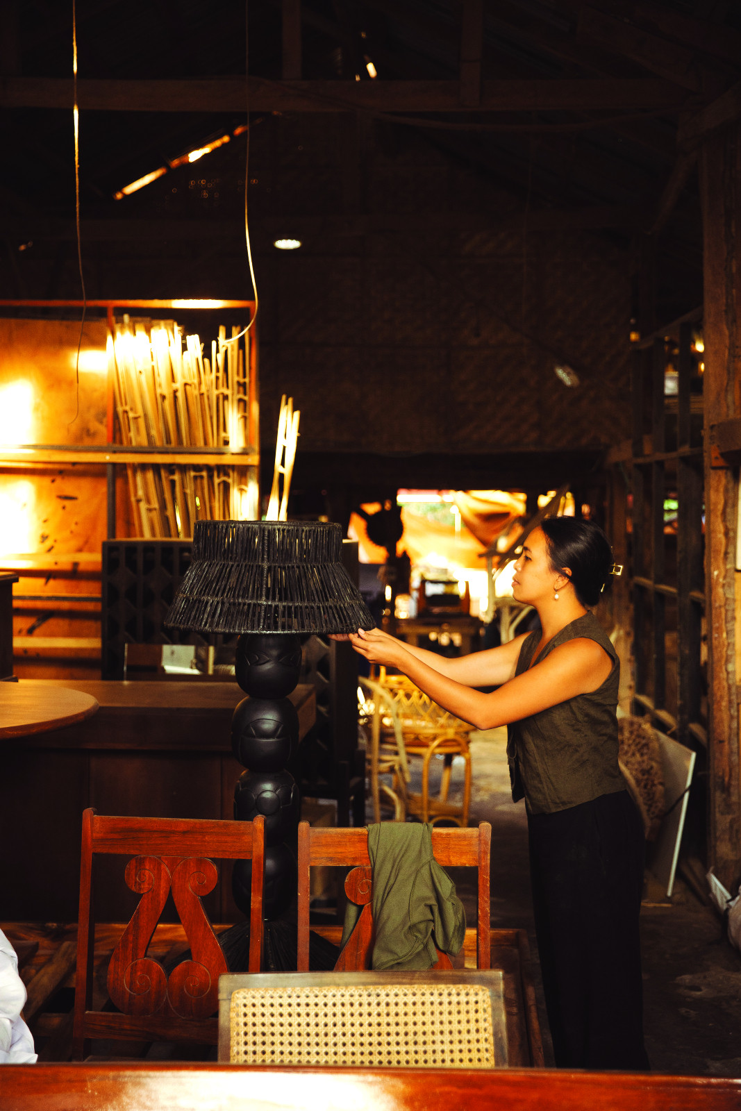 Vanessa Gaston in her community-led workshop, Tropique Living, adjusting the Anito Lamp