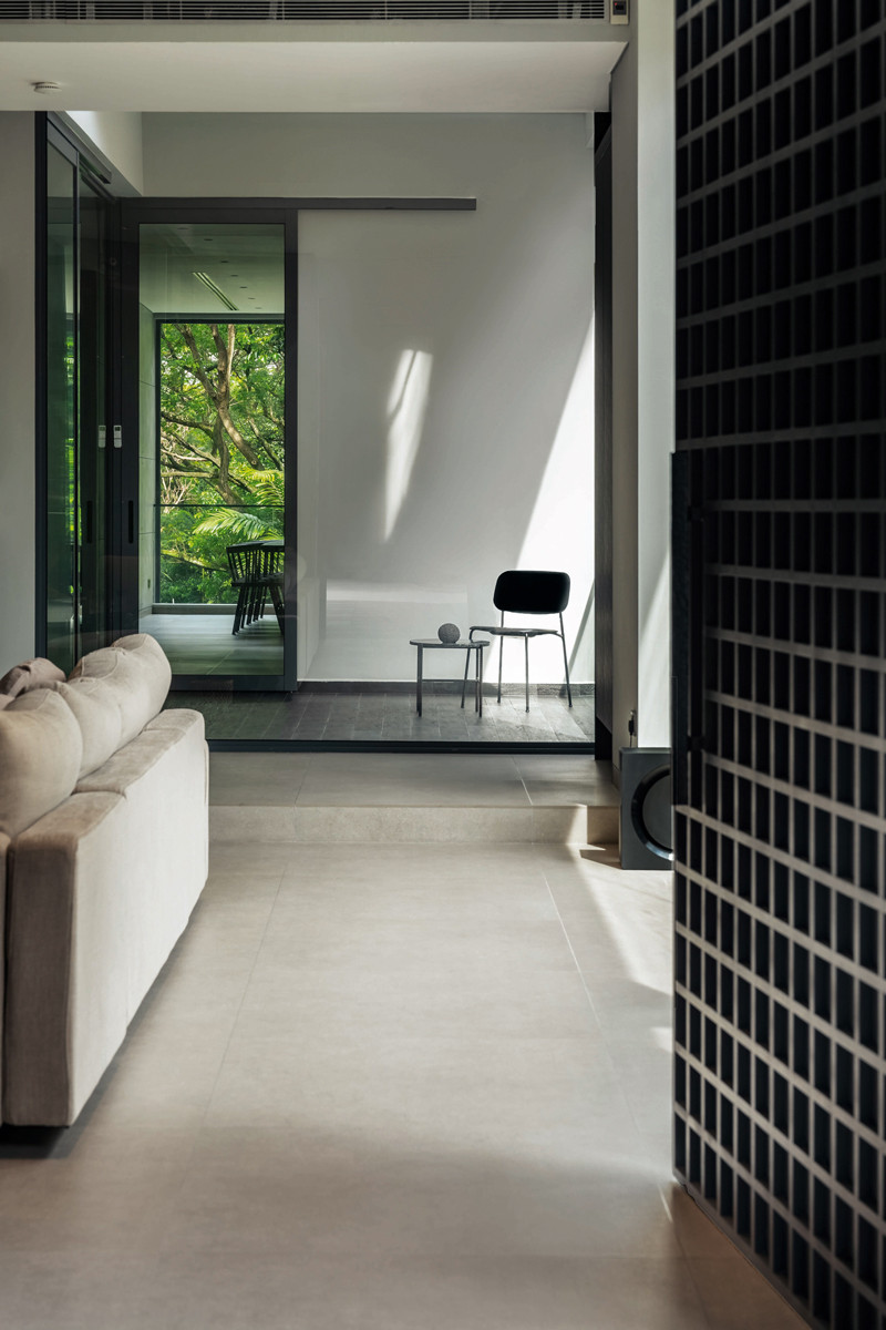 The living room opens up to views of lush greenery at the rear