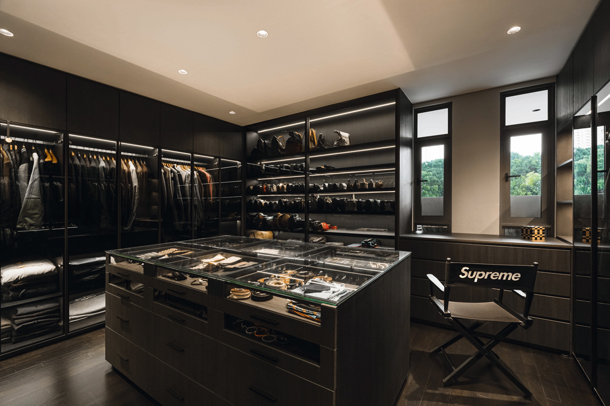 The walk-in wardrobe is clad in a sumptuous dark material palette