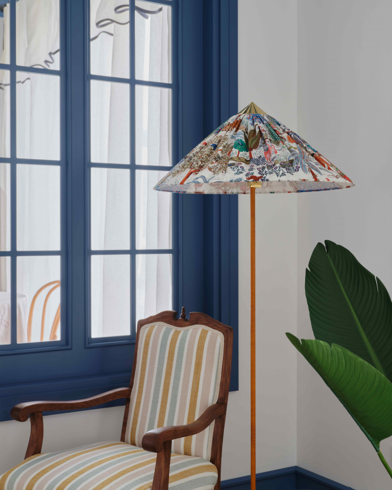A reupholstered vintage armchair complements a Gubi floor lamp with Pierre Frey fabric