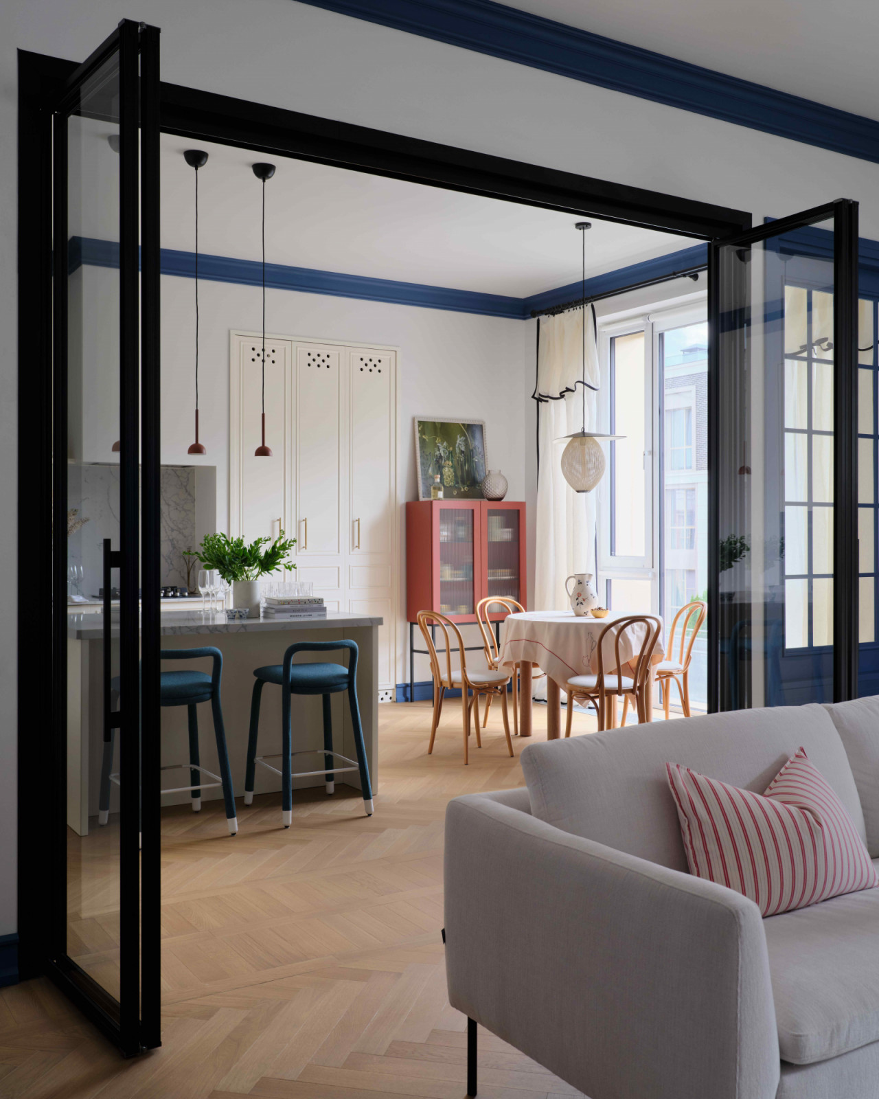 Folding glass doors open into the kitchen and dining area