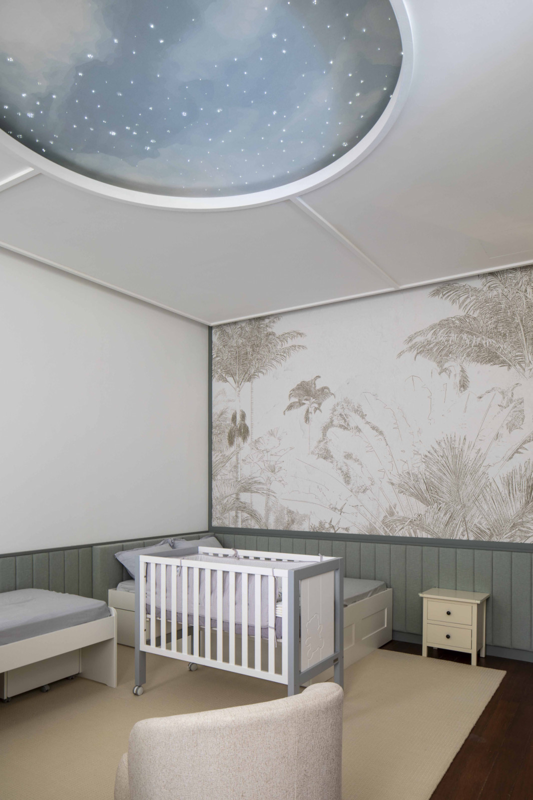 The black-and-white house’s nursery features soft materials and a soothing colour palette, with a mesmerising ceiling light that mimics a constellation-filled sky