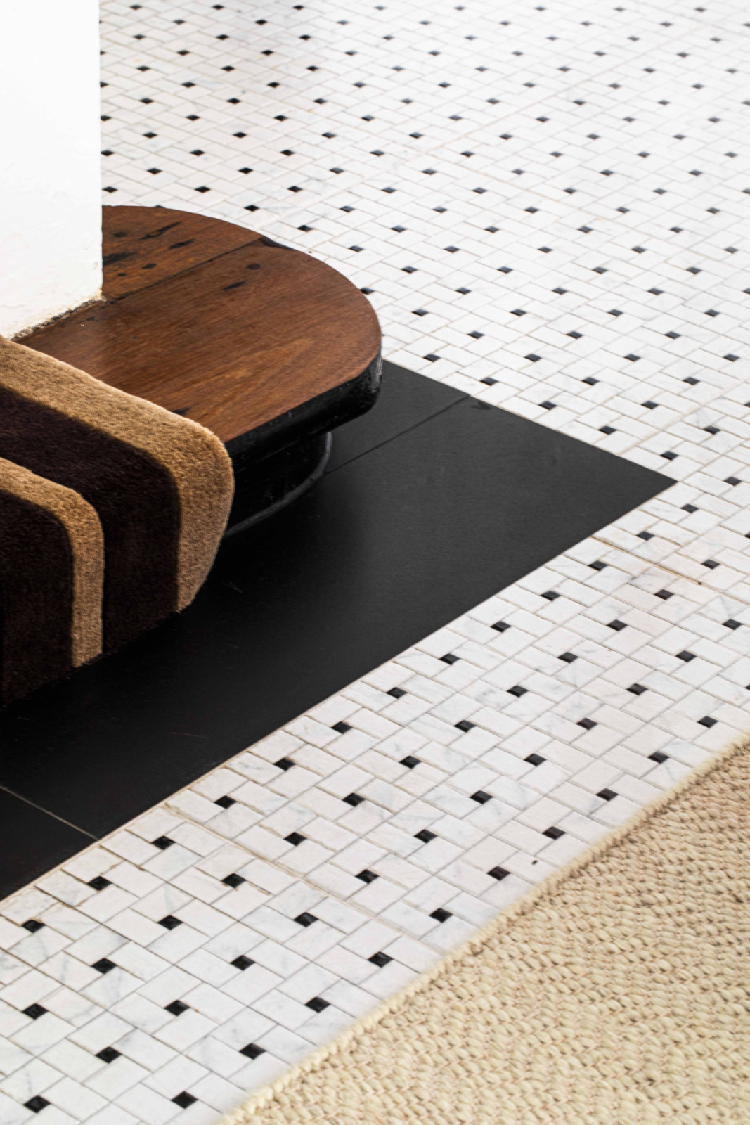 A close-up detail reveals the meeting of materials, adding depth and richness to the black-and-white house’s tactile palette