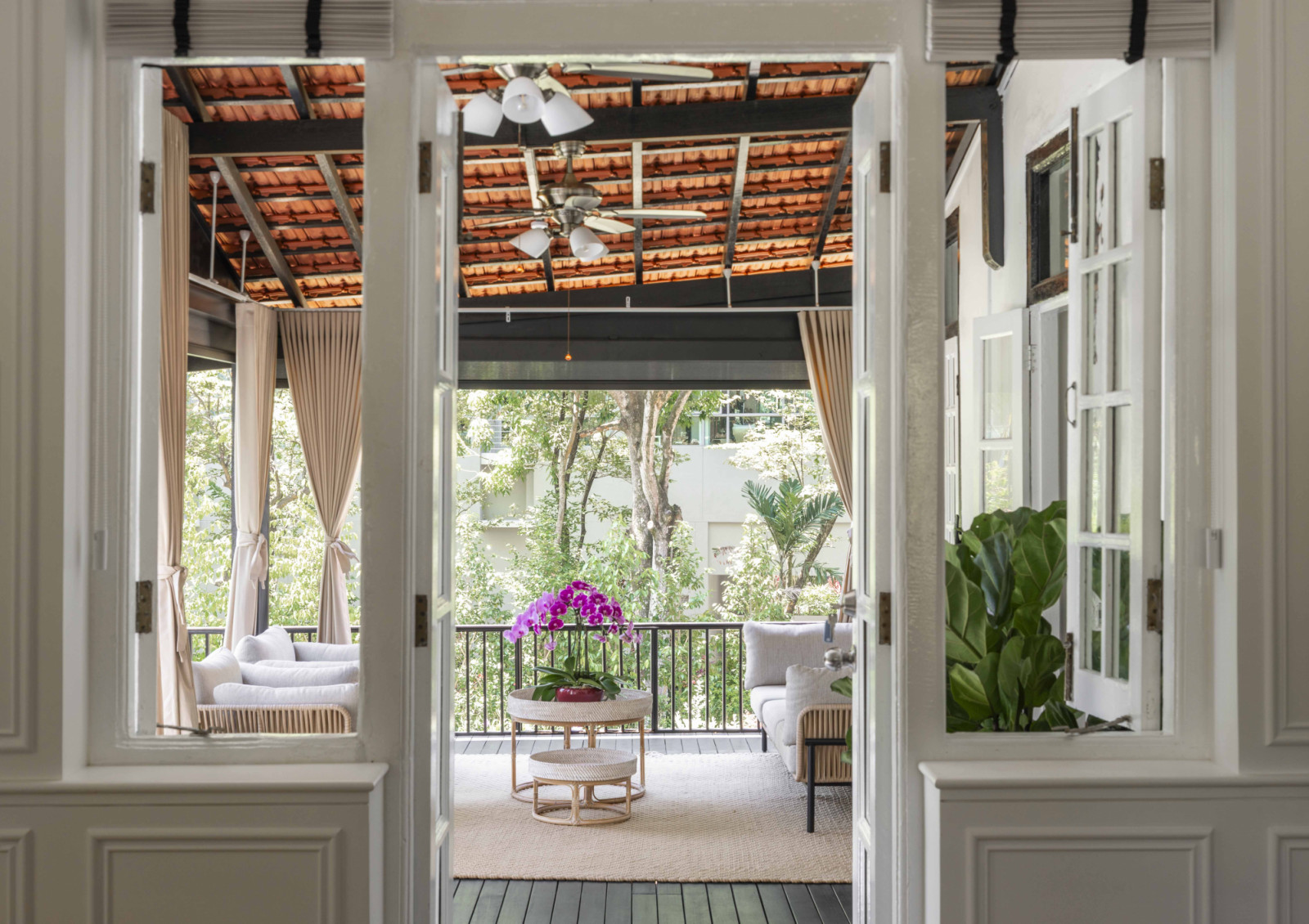 This sheltered outdoor seating area overlooks the black-and-white house’s verdant grounds, offering a well-appointed spot for leisure time
