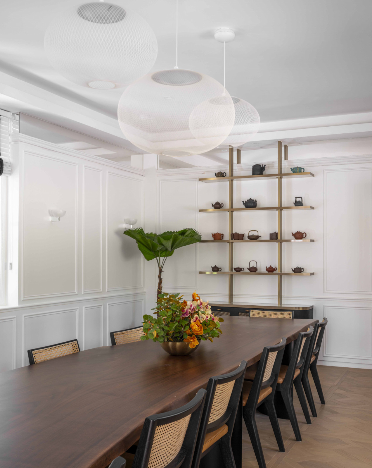 The elegant dining room features oversized transparent pendants that feel light despite their scale, complemented by floral arrangements from This Humid House—refreshed every fortnight to keep the space feeling alive