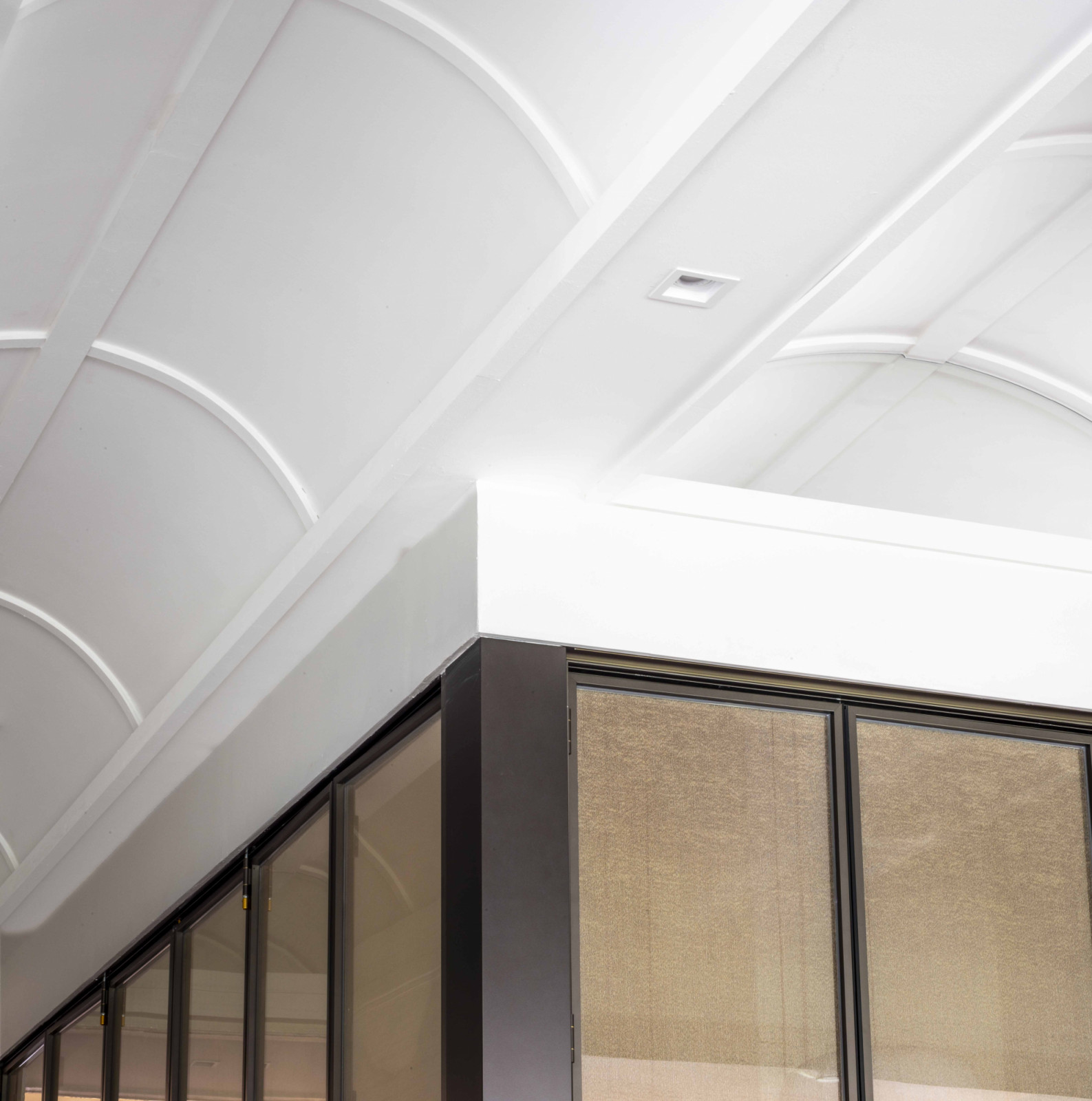 A close-up detail of the curving ceiling articulation highlights the craftsmanship and structural finesse