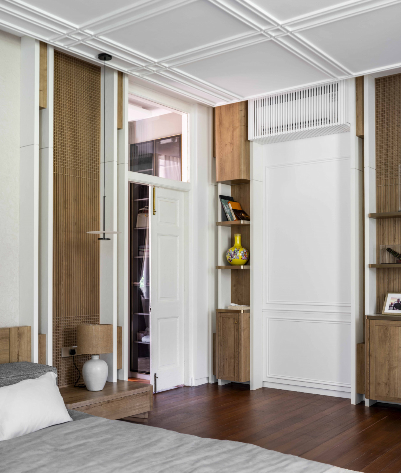 The bedroom walls feature recessed niches in warm finishes, designed to showcase the homeowner’s curated collectibles