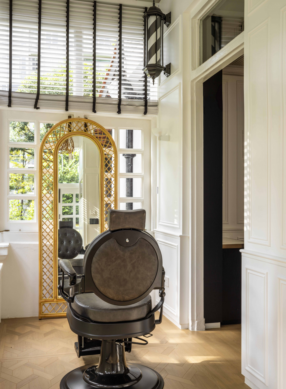 A vintage barber chair and ornate mirror add a sense of charm and whimsy to the sunroom