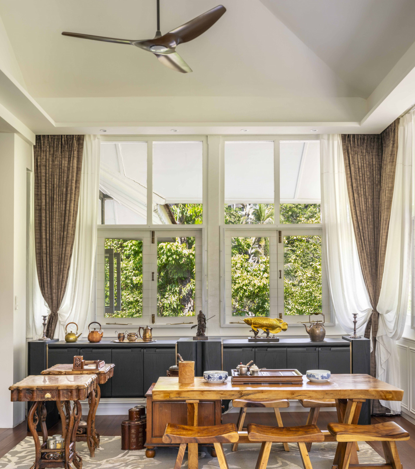 The black-and-white house’s upstairs lounge doubles as a tea room and meeting space, complete with antique tables and collected objects