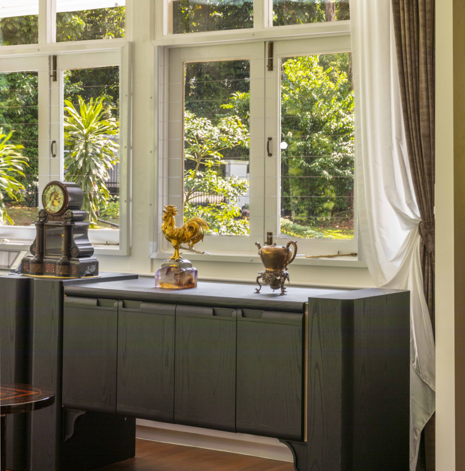 The owner’s personal knick-knacks—such as this antique grandfather clock and gilded figurines placed atop the cupboard in the tea room—reflect a blend of sentiment, heritage, and feng shui principles