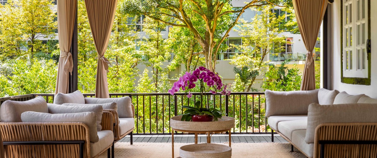 The generous outdoor seating area overlooks lush greenery, offering a tranquil spot for relaxation and entertaining