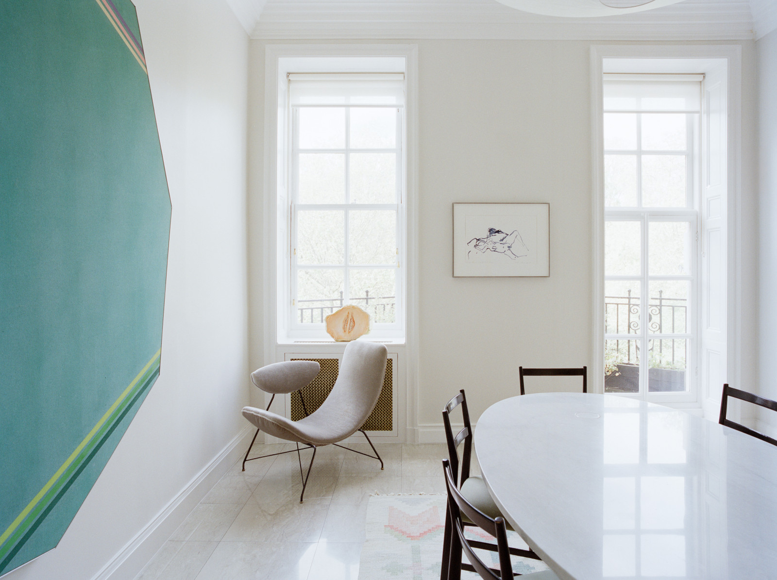 Exploring the unique details of Lawrence Van Hagen's London home, particularly the dining room with works by Kenneth Noland and Tracey Emin with an Angelo Mangiarotti table, Gio Ponti Chairs, an Ingro Maurer ceiling light overhead and a ‘Reversivel’ chair by Martin Eisler and Carlo Hauner in the corner