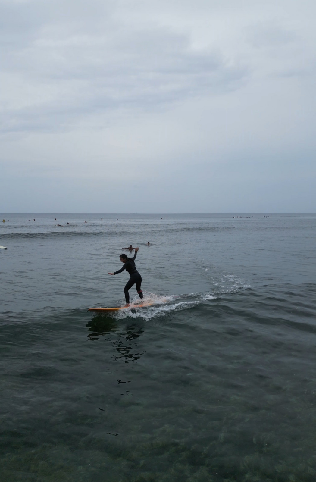 Surfers enjoy at the long, smooth waves of Pacifico Beach in Siargao