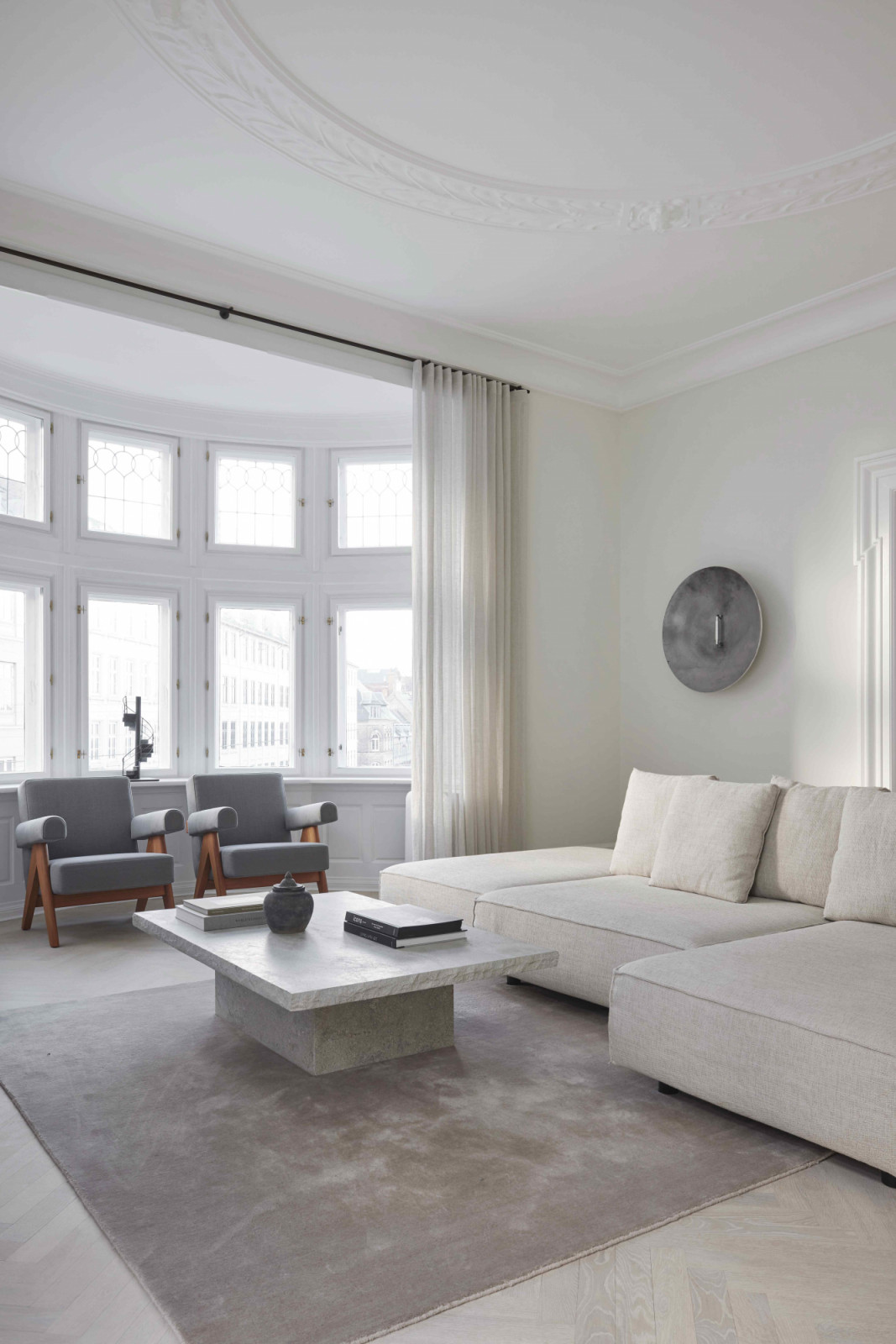 Ample light in the lounge-style living room through the bow windows