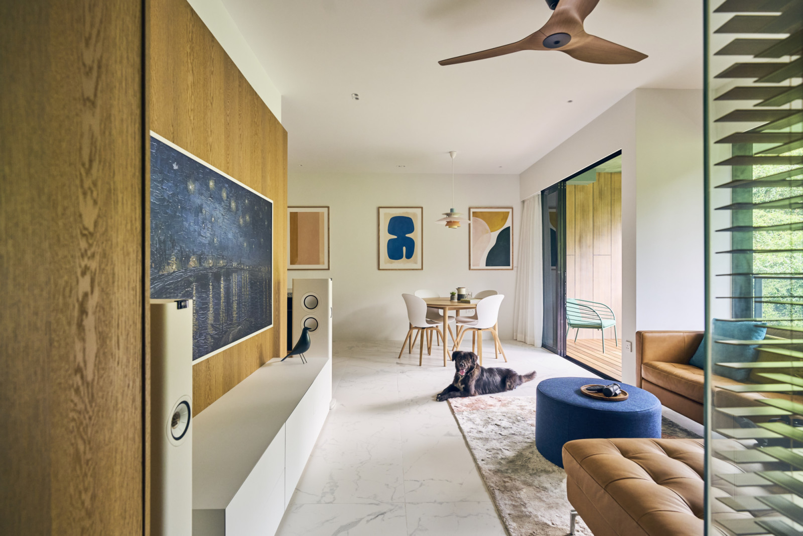 The television was placed unconventionally along the corridor wall, freeing up the main living area to maintain visual focus on the surrounding greenery
