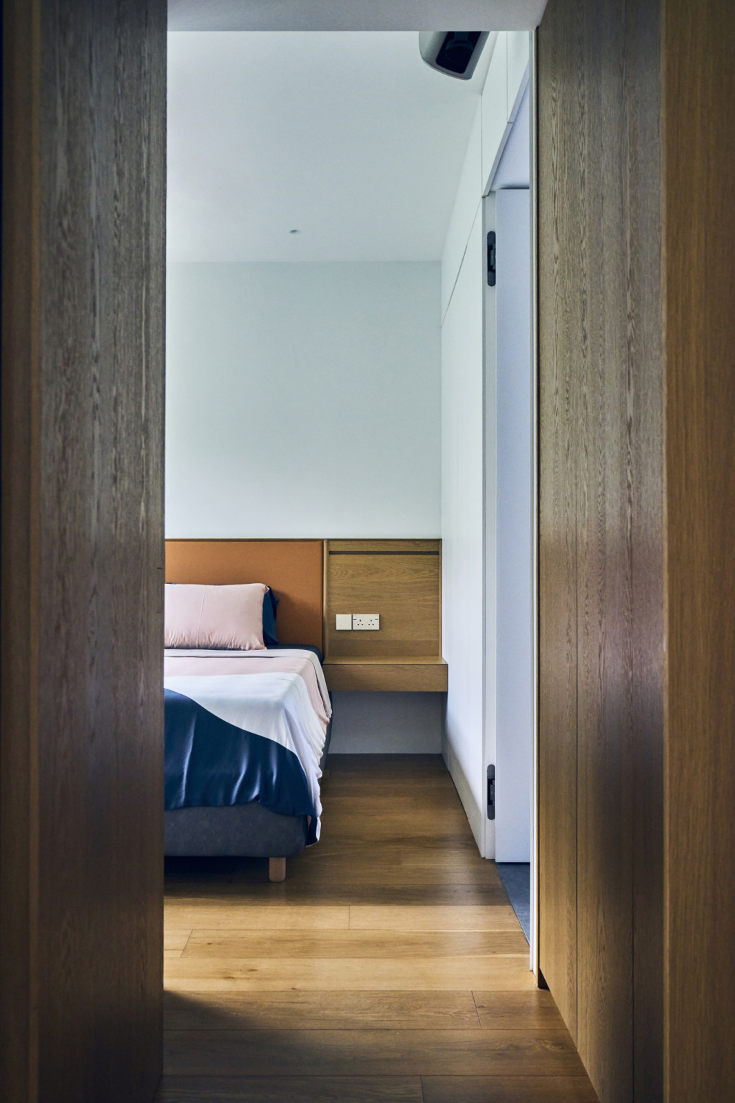 Timber cladding plays a unifying role throughout the apartment, from the entrance foyer and kitchen to the study and master bedroom