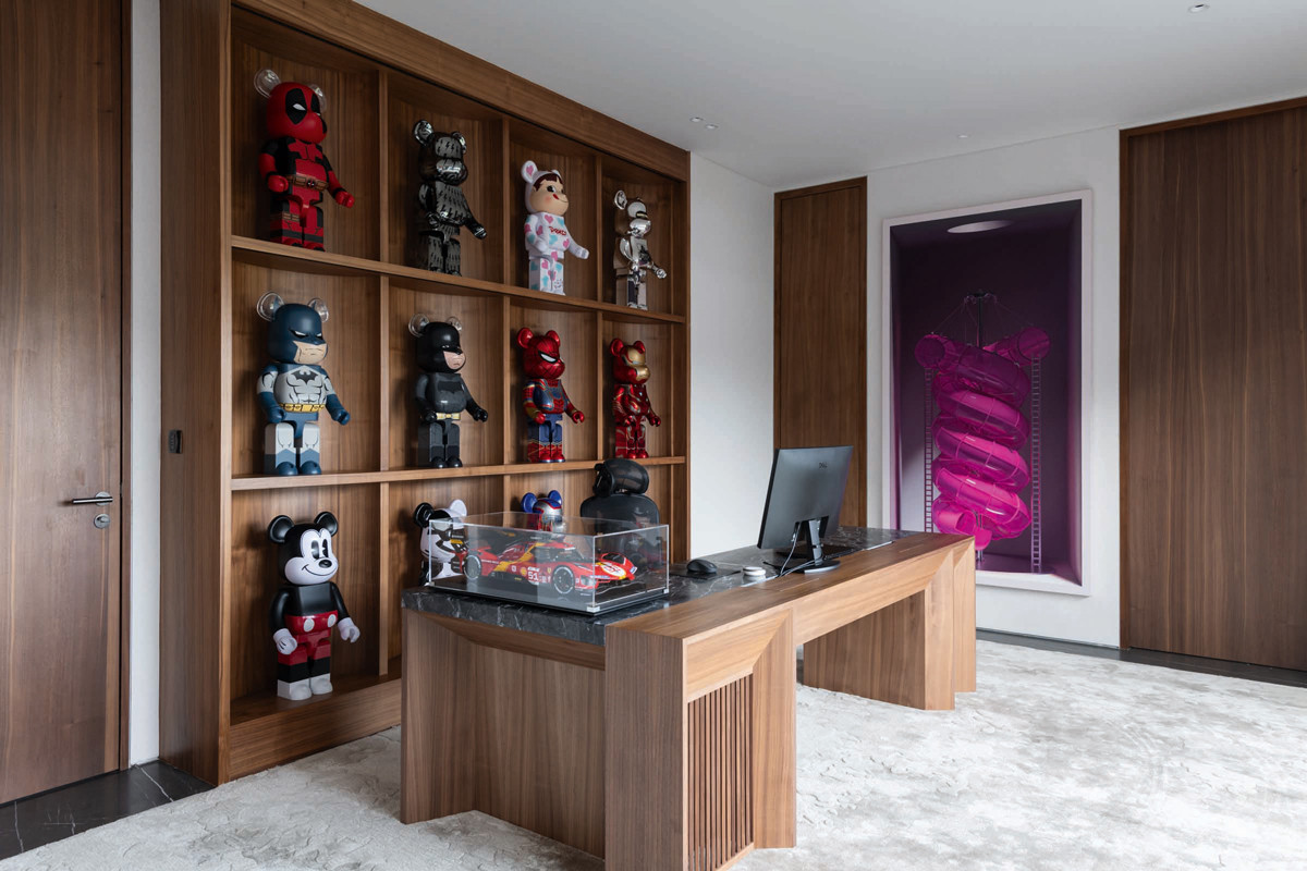 Custom carpentry turns the owner’s Bearbrick collection into a unique feature that goes well with the colourful art collection in this home by Architology Interiors