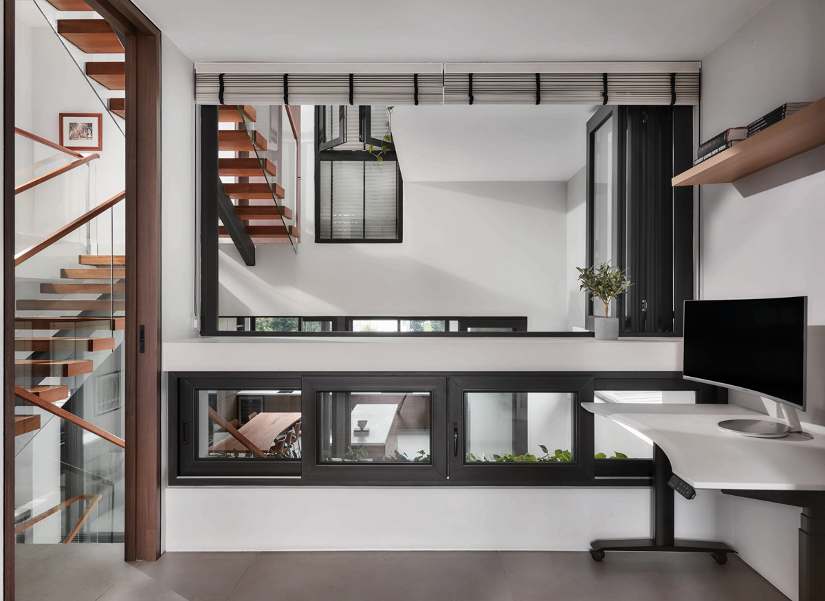 A porous perspective from the study showcases the terrace house’s vertical articulation