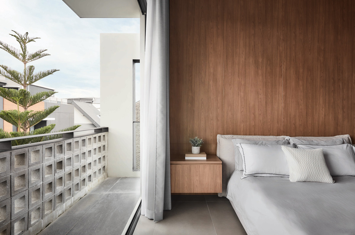 This bedroom opens out to a balcony with a railing constructed from breeze blocks