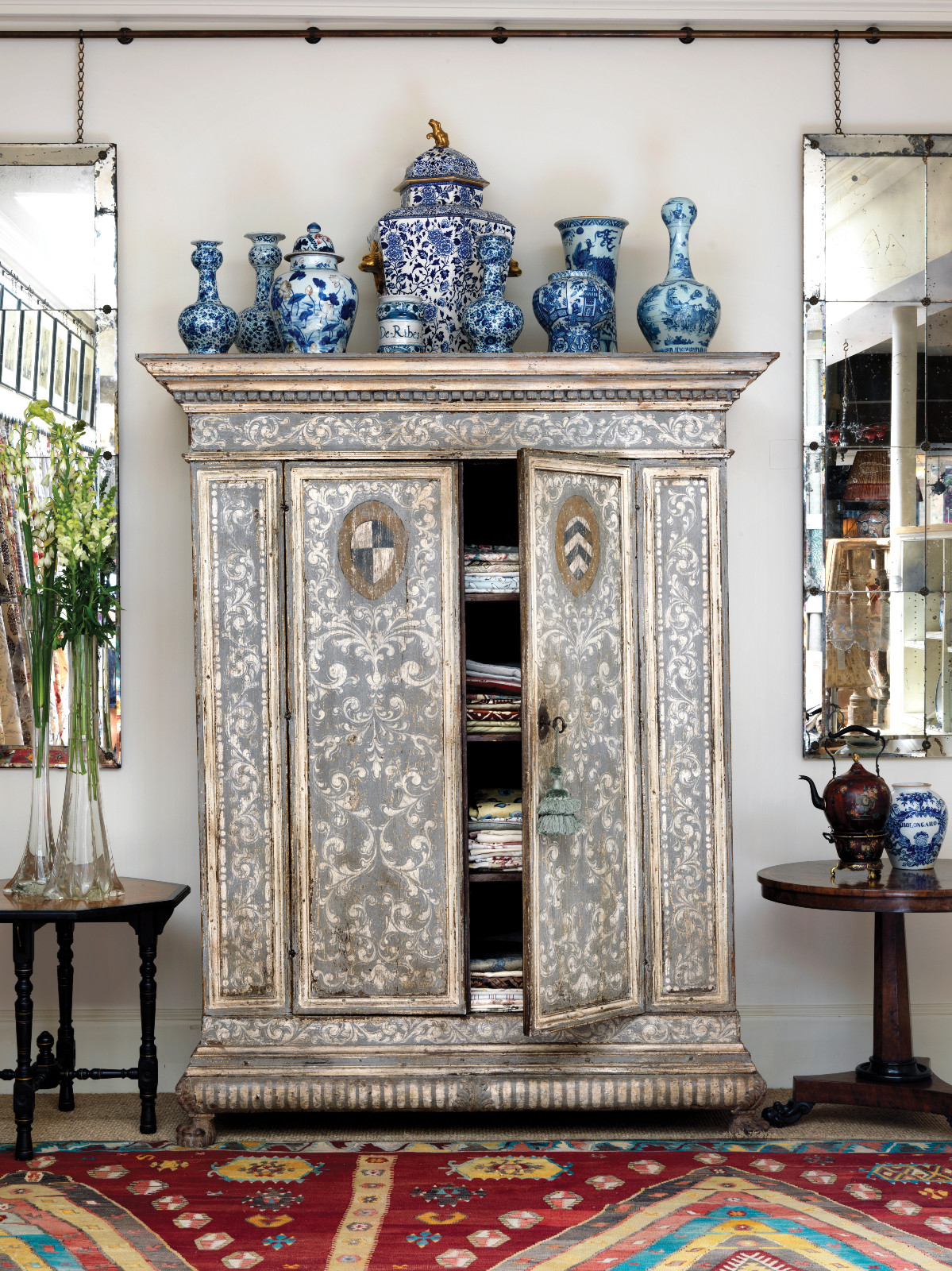 An armoire at Robert Kime’s showroom on Ebury Street, London, topped with a selection of blue and white jars