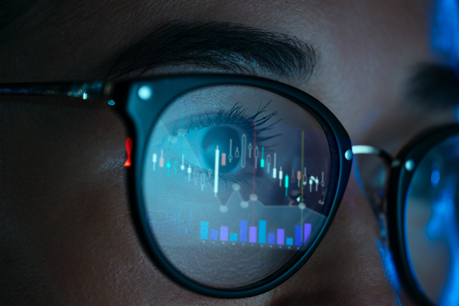 Female trader wearing eyeglasses with reflection of stock market charts (ภาพ: D-Keine via Getty Images)