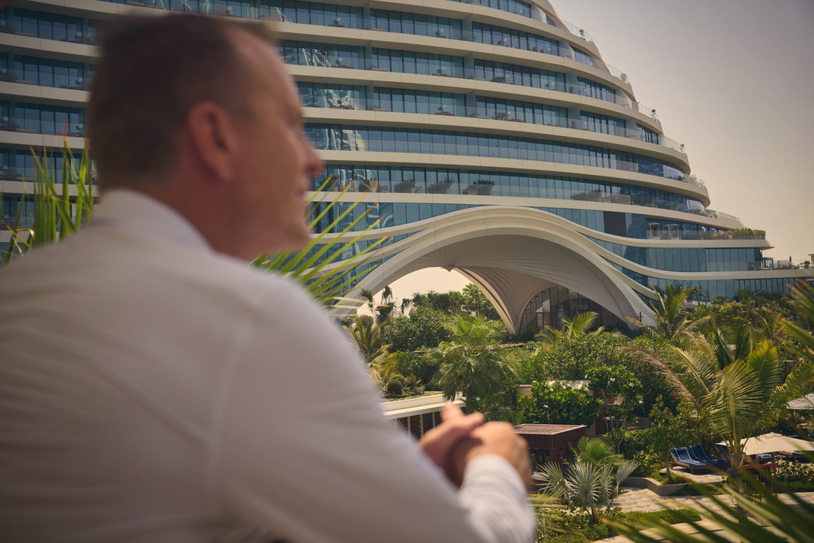 Shaun Killa observes his latest creation, Jumeirah Marsa Al Arab, from a nearby vantage point, with the hotel's signature arch framing the iconic Burj Al Arab in the distance