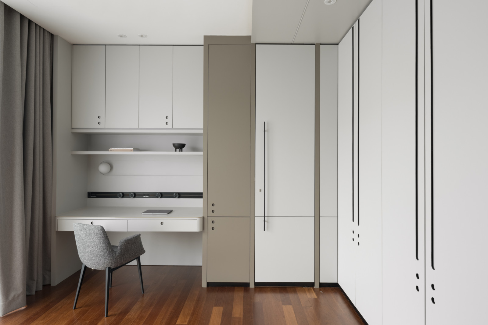 A secondary living area on the first floor features elegant wood flooring and custom joinery, including a built-in desk