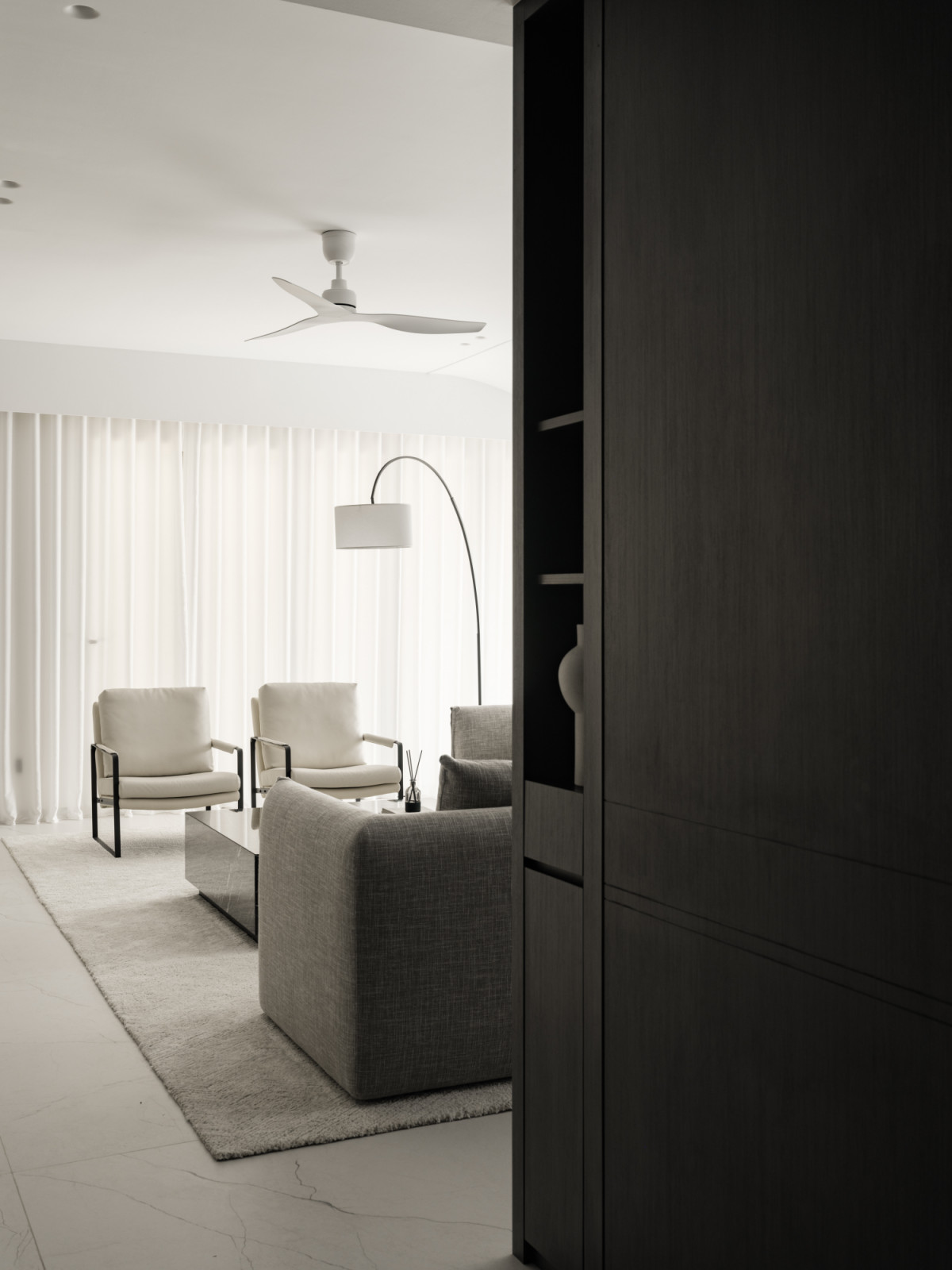 The living area's careful material selection balances solid black surfaces with lighter elements