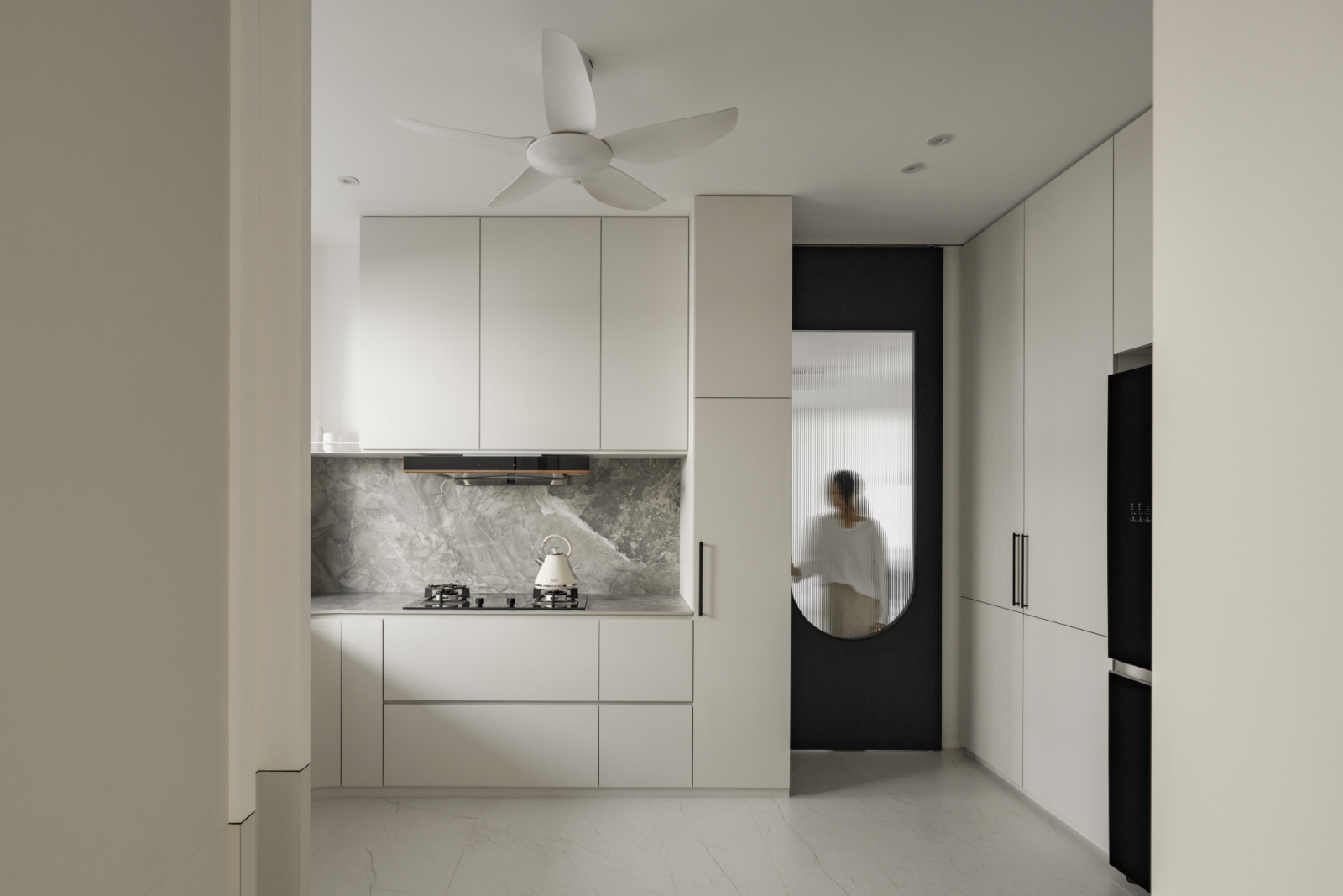 The wet kitchen features cream marble surfaces and integrated appliances