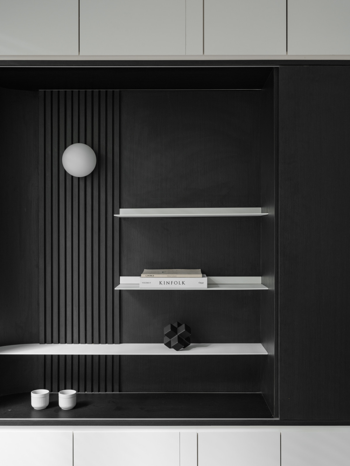 A custom shelving unit with black accent elements creates depth throughout the space