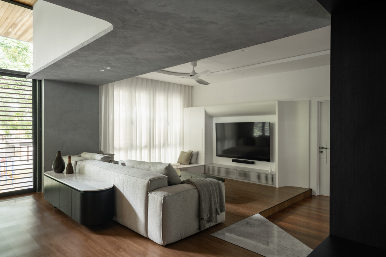 The first floor family area shows the elegant wood flooring alongside the custom media cabinet