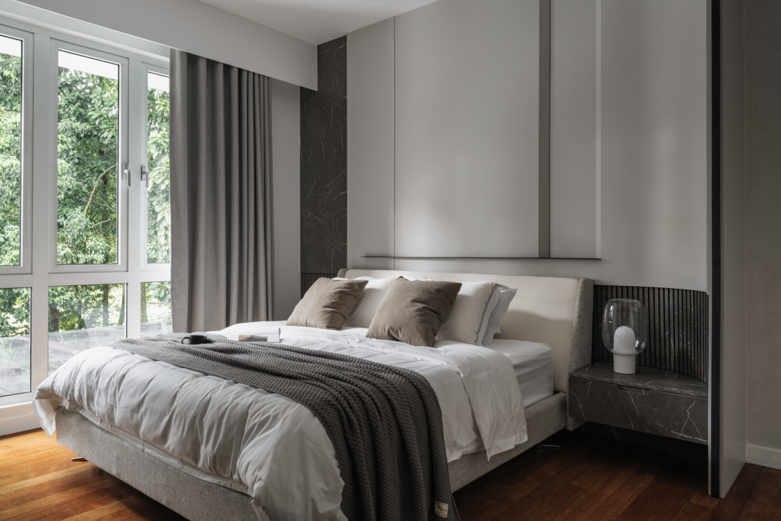The master bedroom, viewed from another angle, showcases the neutral bedding and built-in headboard storage