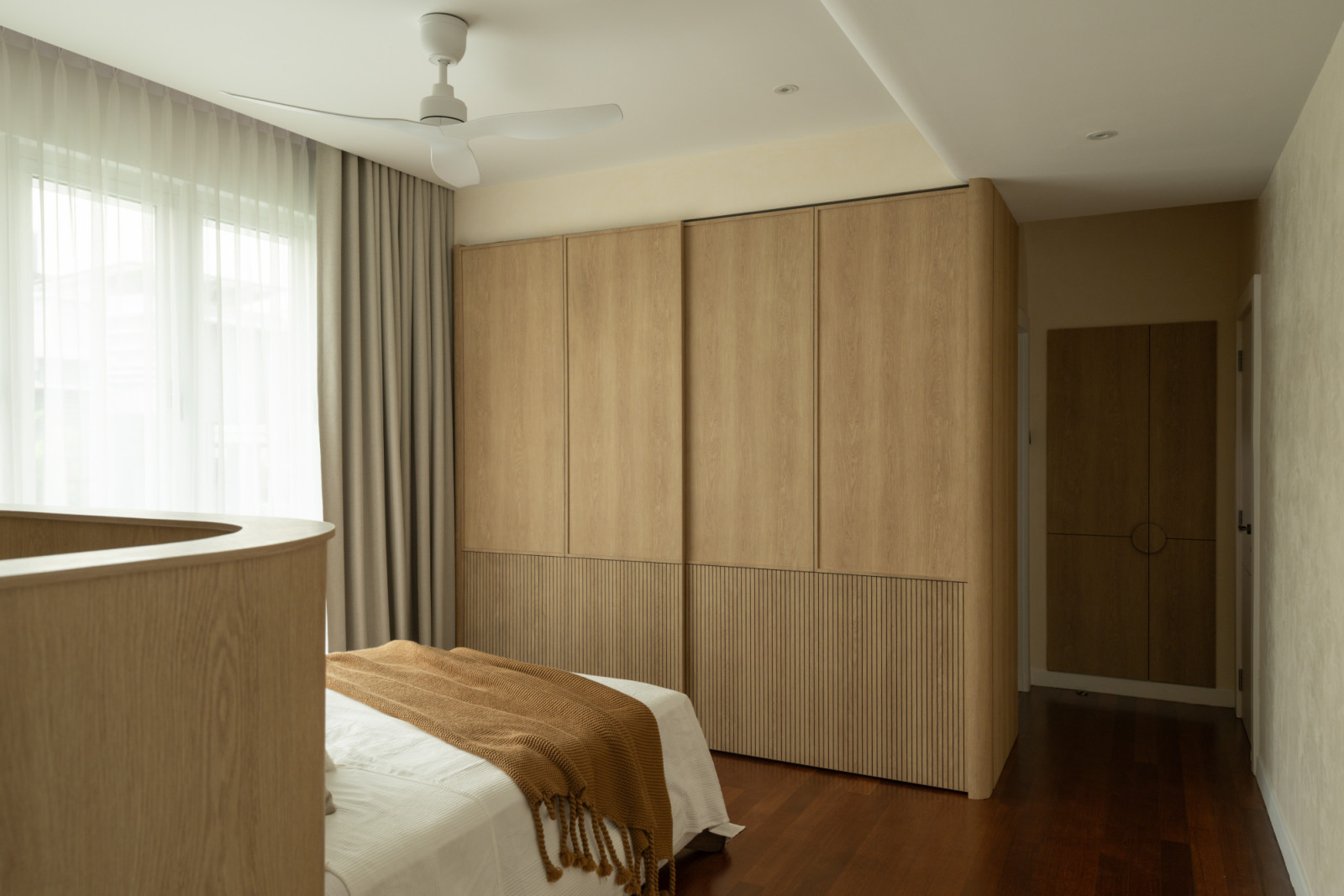 Natural timber wardrobes with textured lower panels provide ample storage whilst introducing warmth to the neutral colour scheme