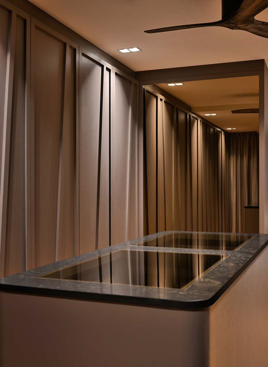 The custom walk-in wardrobe cleverly incorporates geometric motifs inspired by the drape of the curtains for a cohesive look