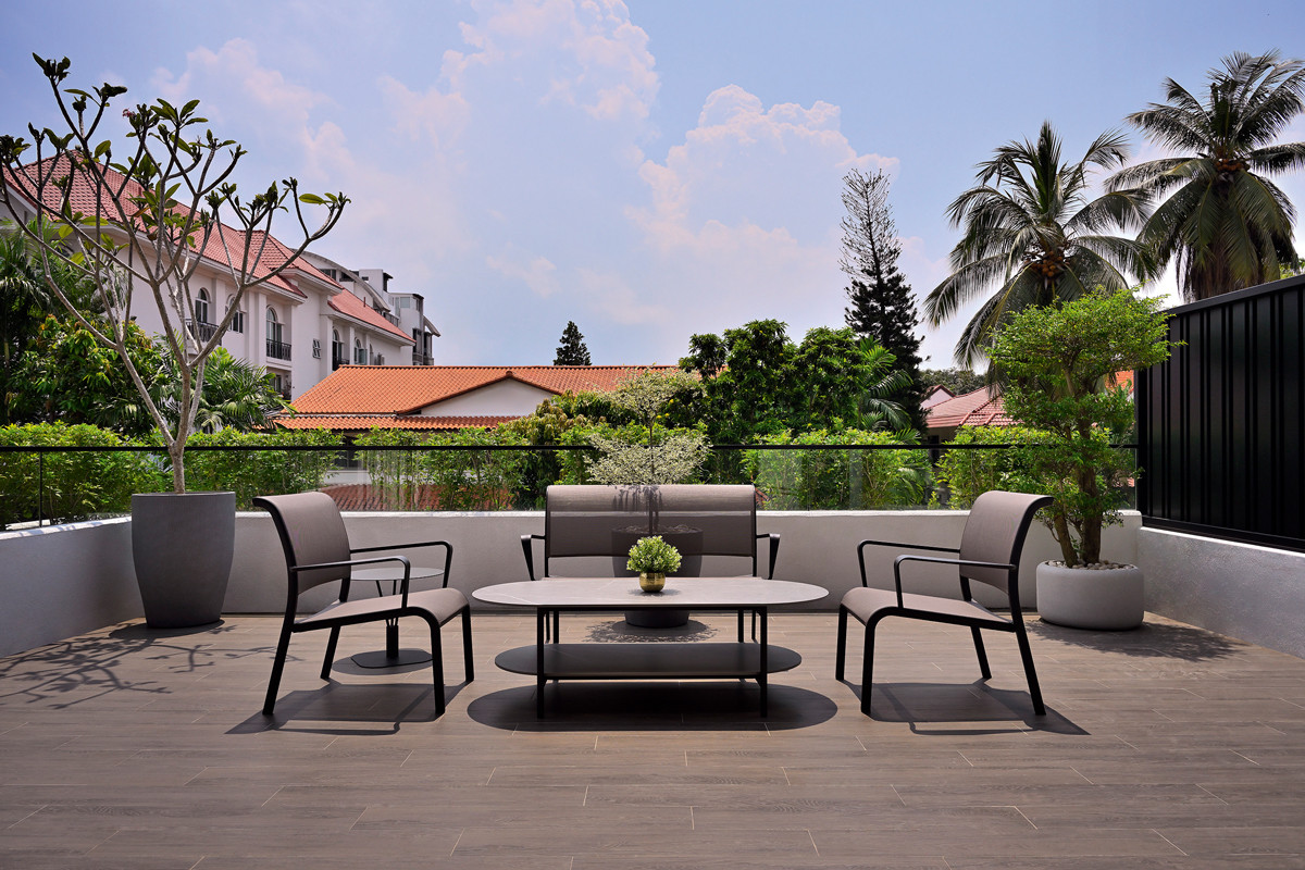 The terrace house’s spacious outdoor lounging area is bordered by rejuvenating greenery