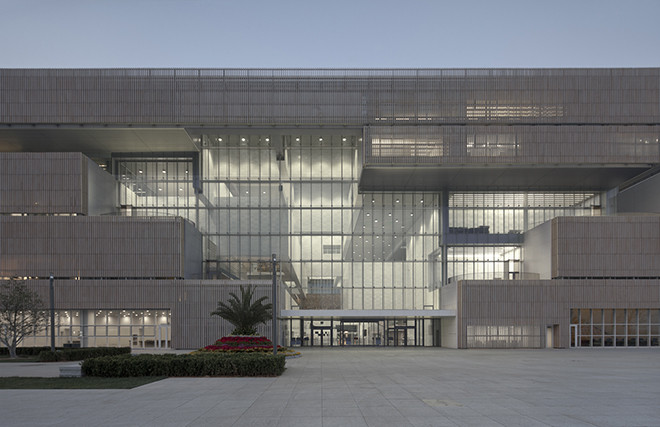 The exterior of Riken Yamamoto’s Tianjin Library, a monumental yet permeable civic space where bookshelves are embedded in a structural grid