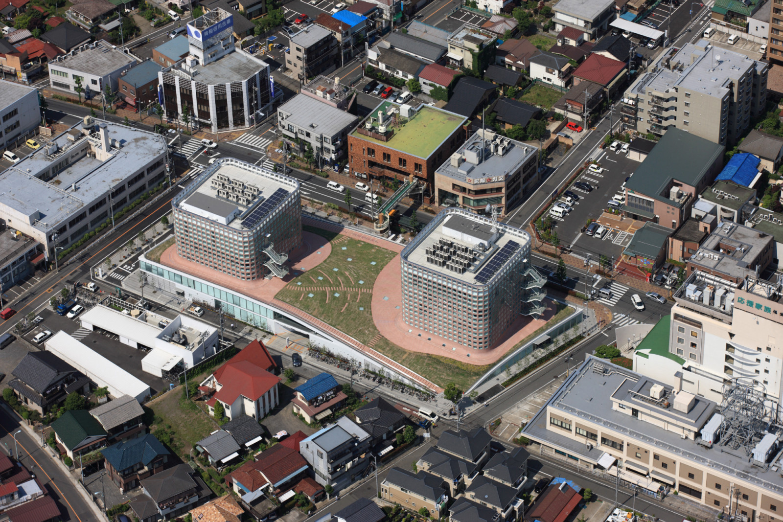 From above, Fussa City Hall blends into its low-rise Tokyo suburb, its undulating green roof doubling as a public park and civic gathering space.