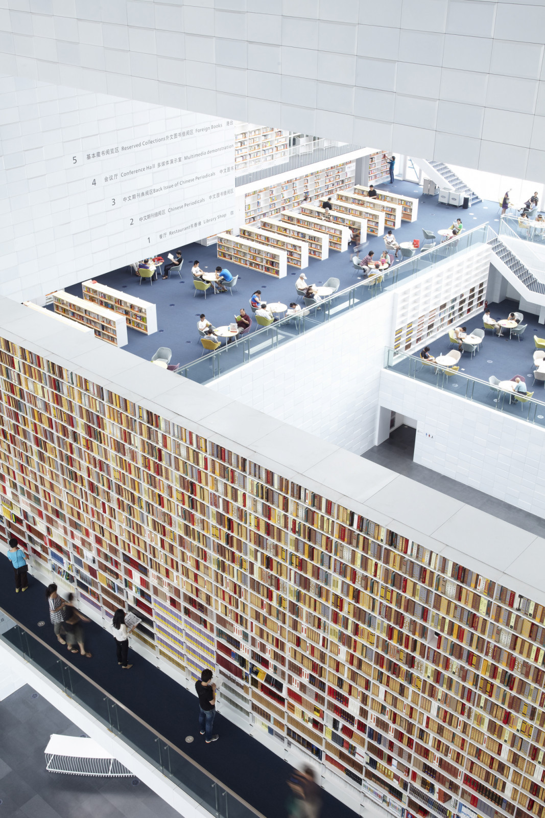 Inside Tianjin Library, rows of wall-integrated bookshelves and open, overlapping levels create a continuous reading landscape