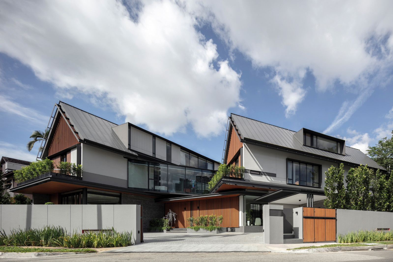 Like a modern kampung house, the home features steeply pitched roofs that help to quickly drain rainwater away